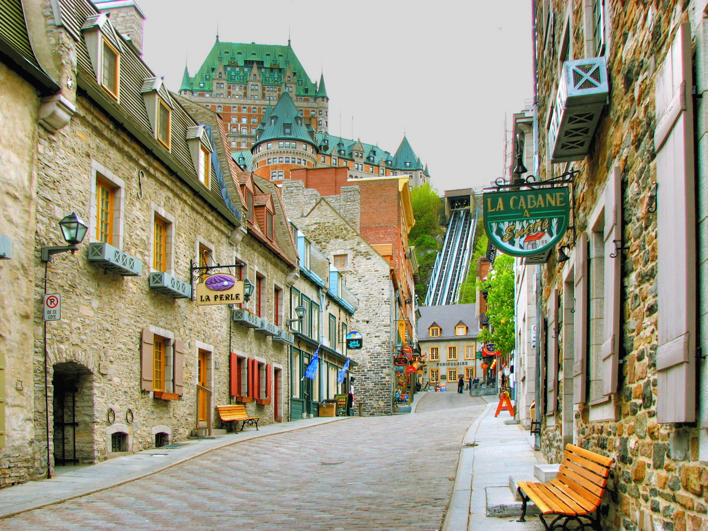 A cobblestoned street in Quebec City with Chateau Frontenac in the background.