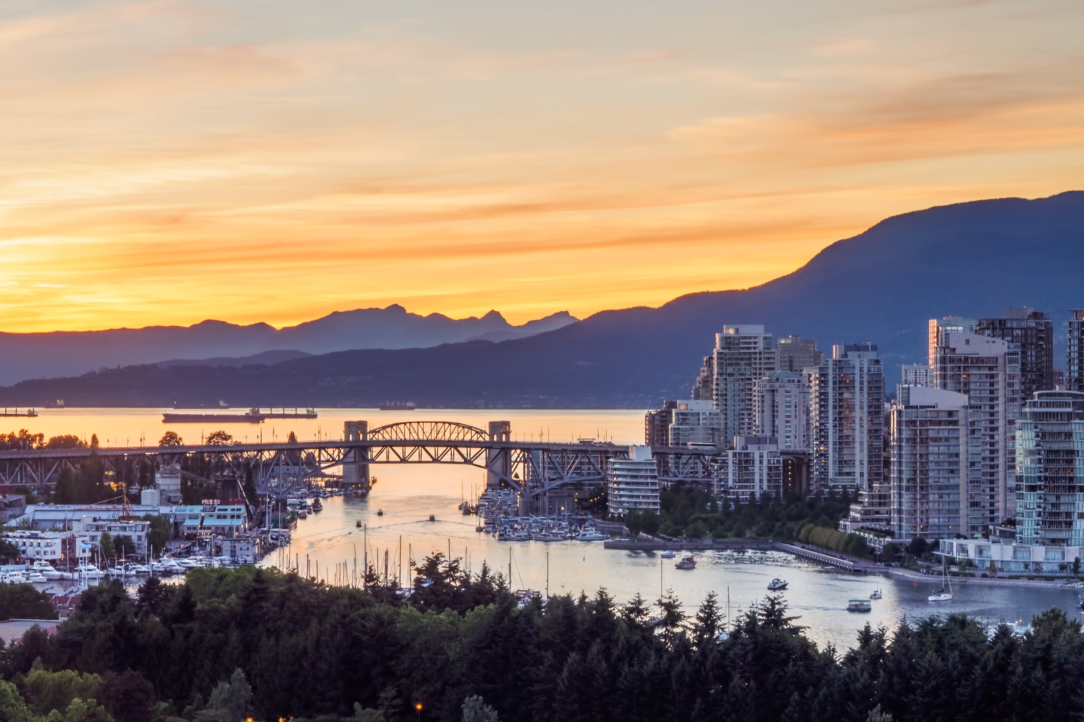 Stanley Park and the Vancouver skyline at sunset.